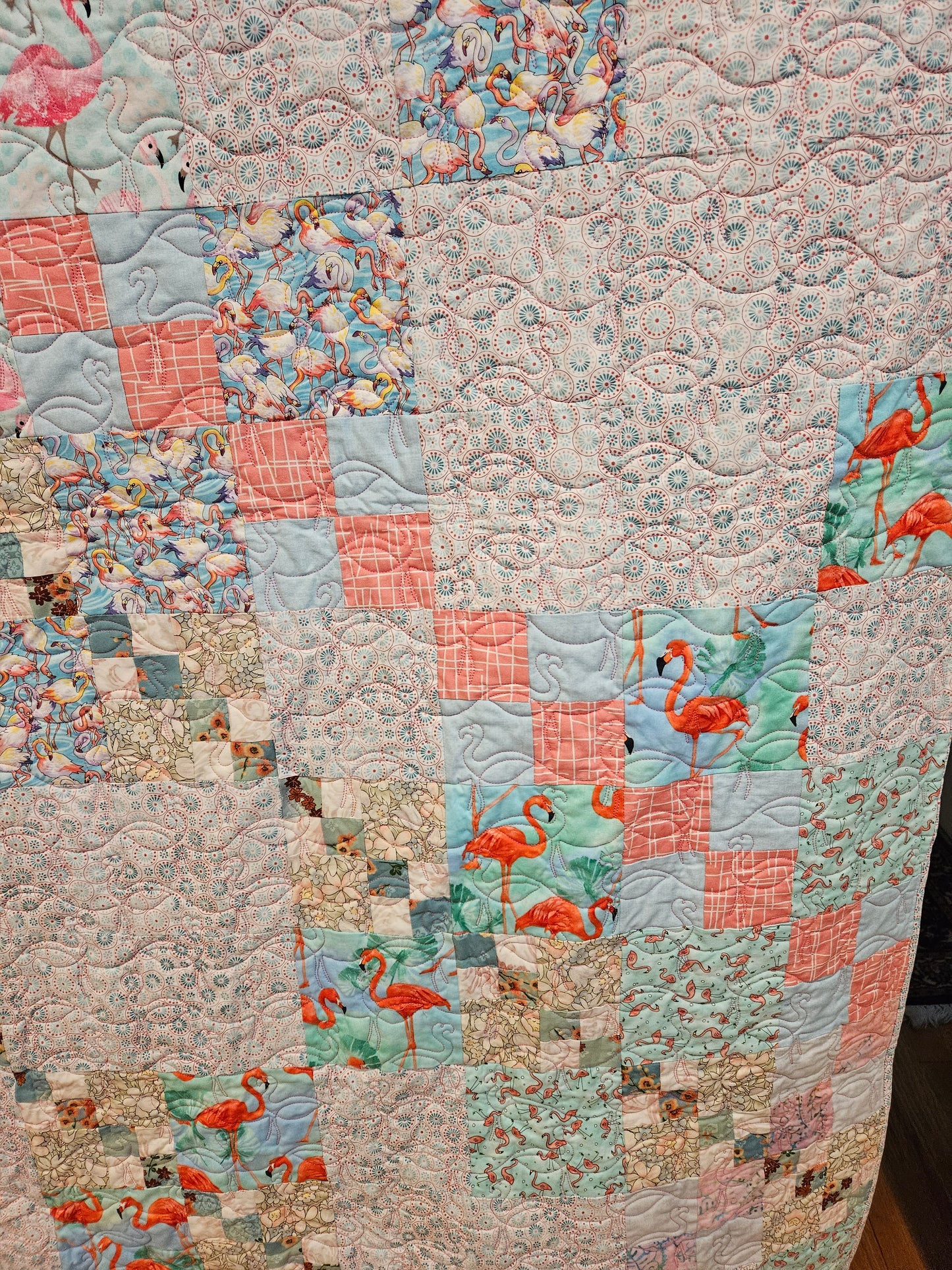 Photo shoing the famingos quilted and in the fabric of the quilt.