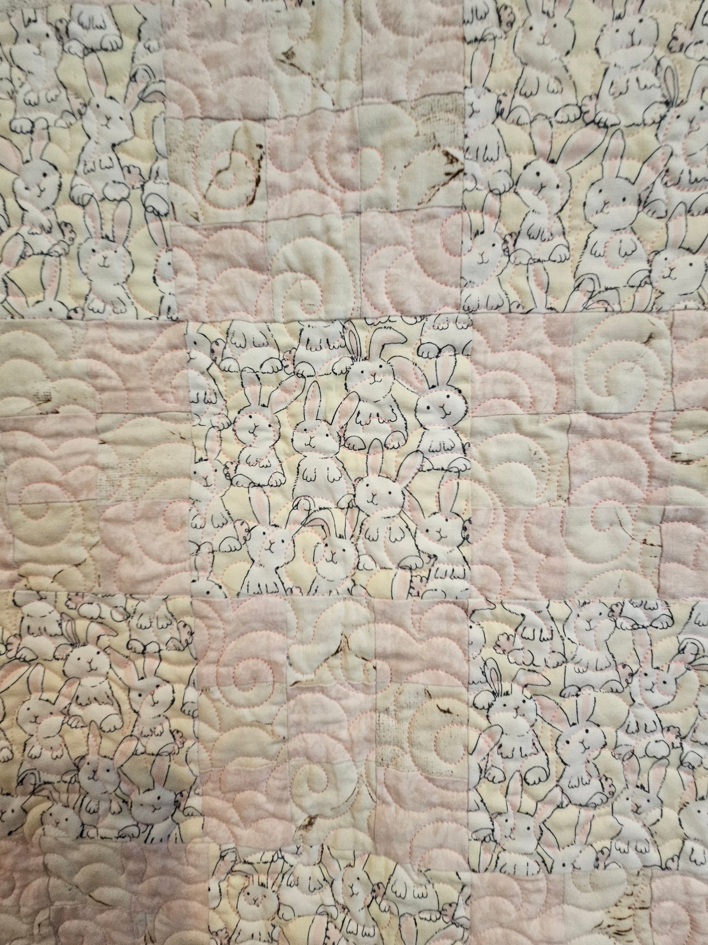 Close up of bunnies and pink and biege quilt blocks