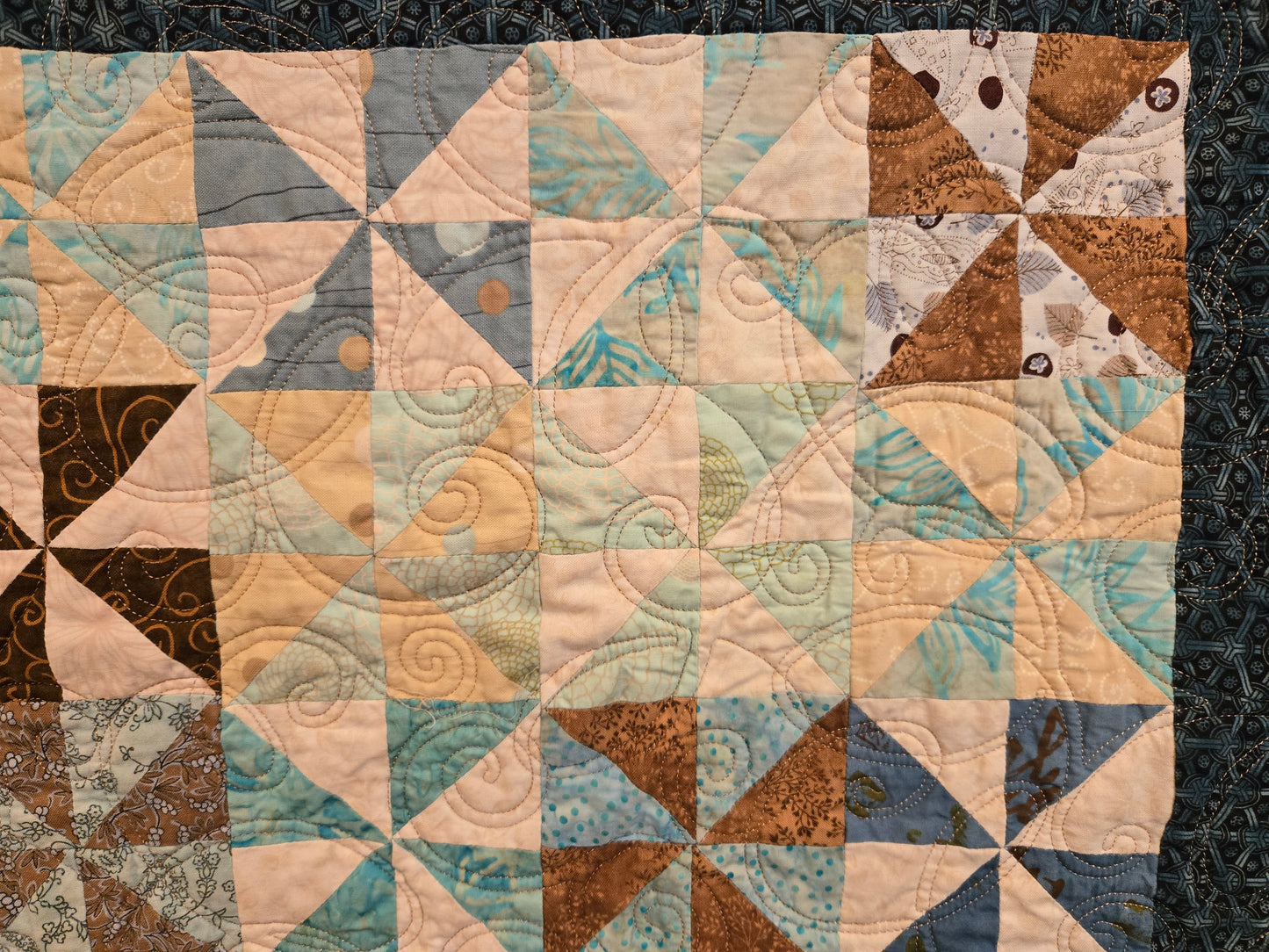 Close up photo of small pinwheels and you can see some of the quilting pattern.