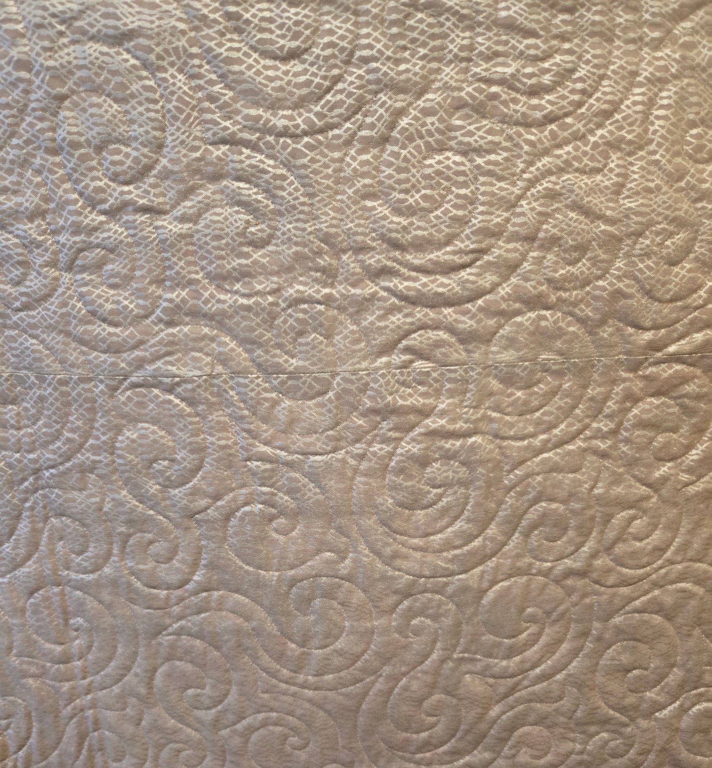 Close up of the back. It is shiney. You can see the quilting well.