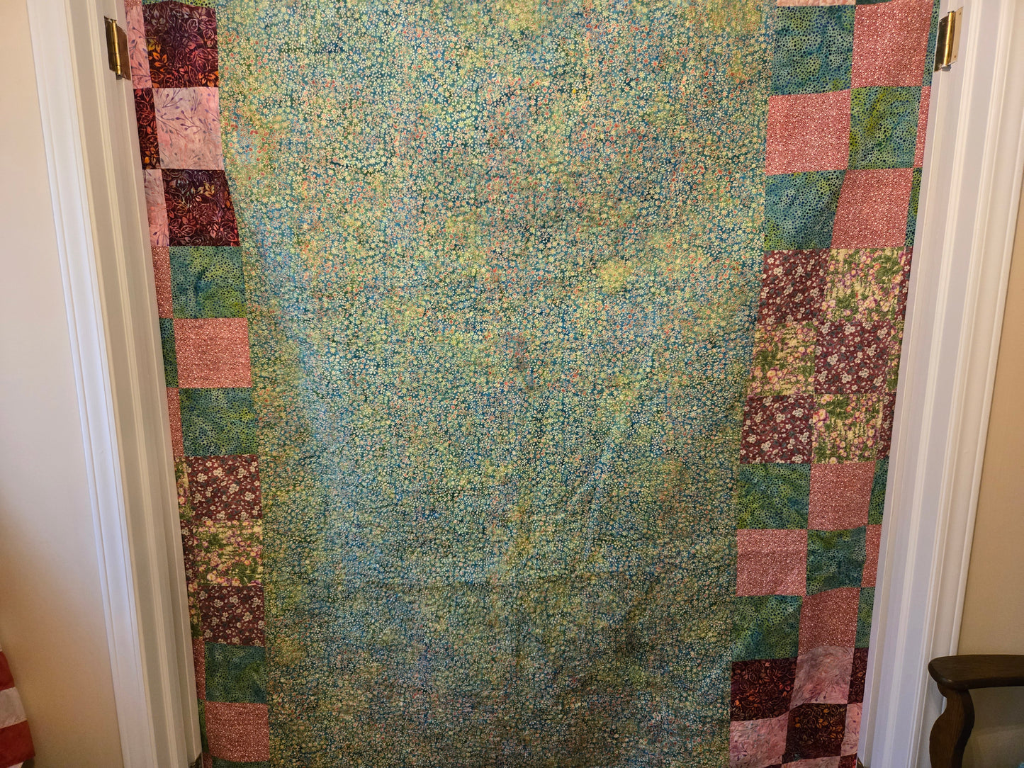 This shows the back of the quilt. I have to take backing fabric that is 10 inches larger all around to the quilter. I started with a solid teal and pink batik and put pink and teal nine patchs on both sides. They're cut off where the quilt ends.