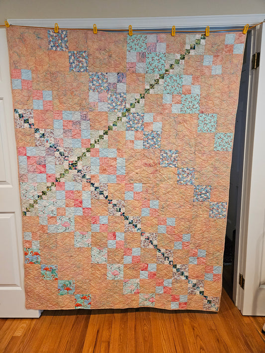 Photo showing entire pink flamingo quilt.  Really a coral color.
