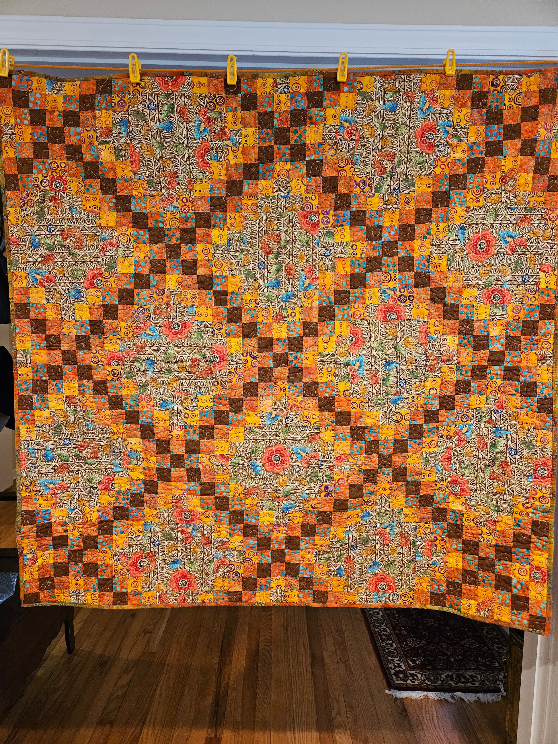 Brown, yellow, orange and red quilt in an triple Irish chain pattern