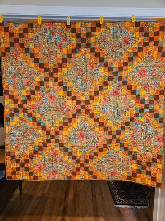 Brown, yellow, orange and red quilt in an triple Irish chain pattern