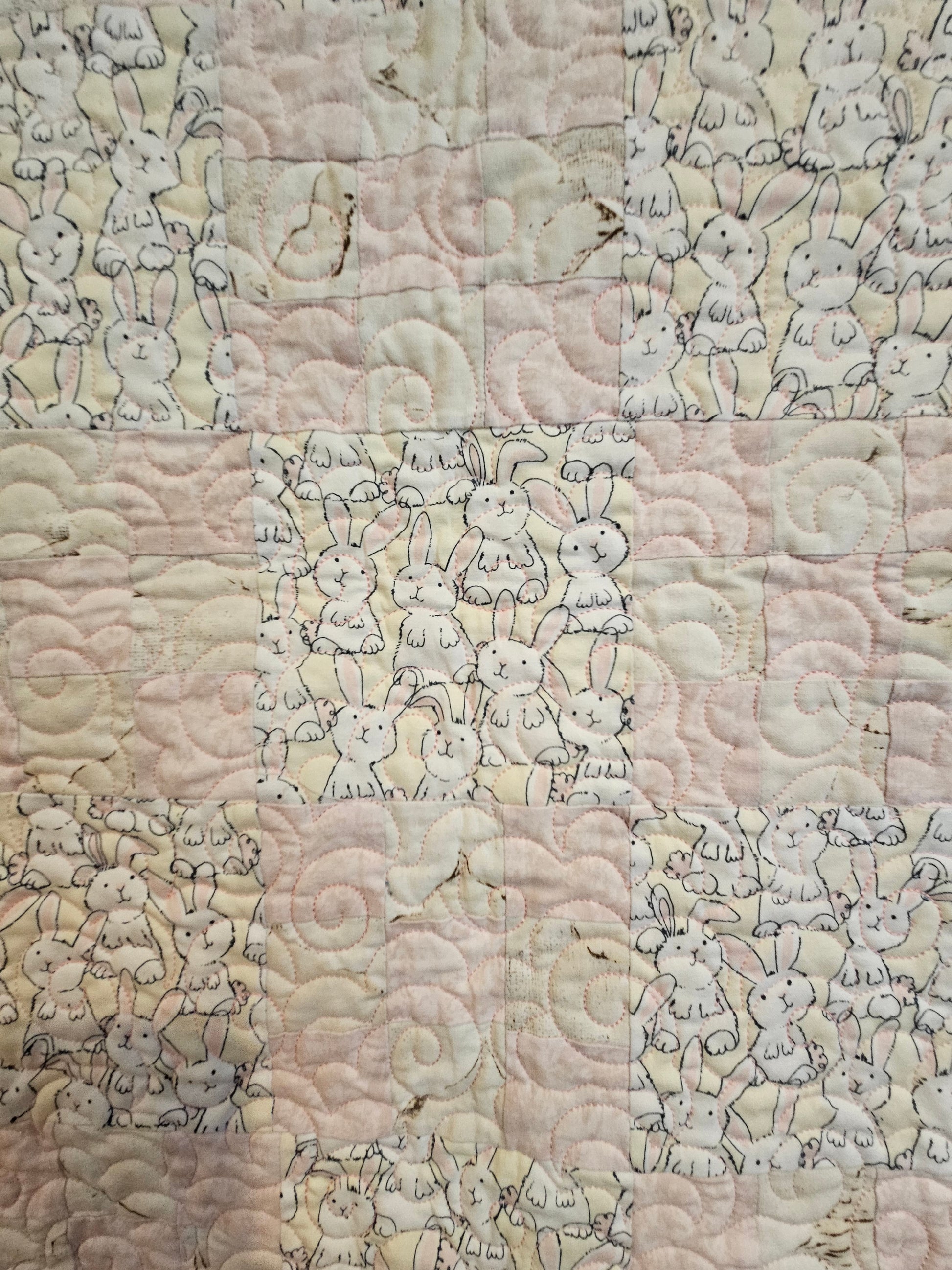 Close up of bunnies and pink and biege quilt blocks