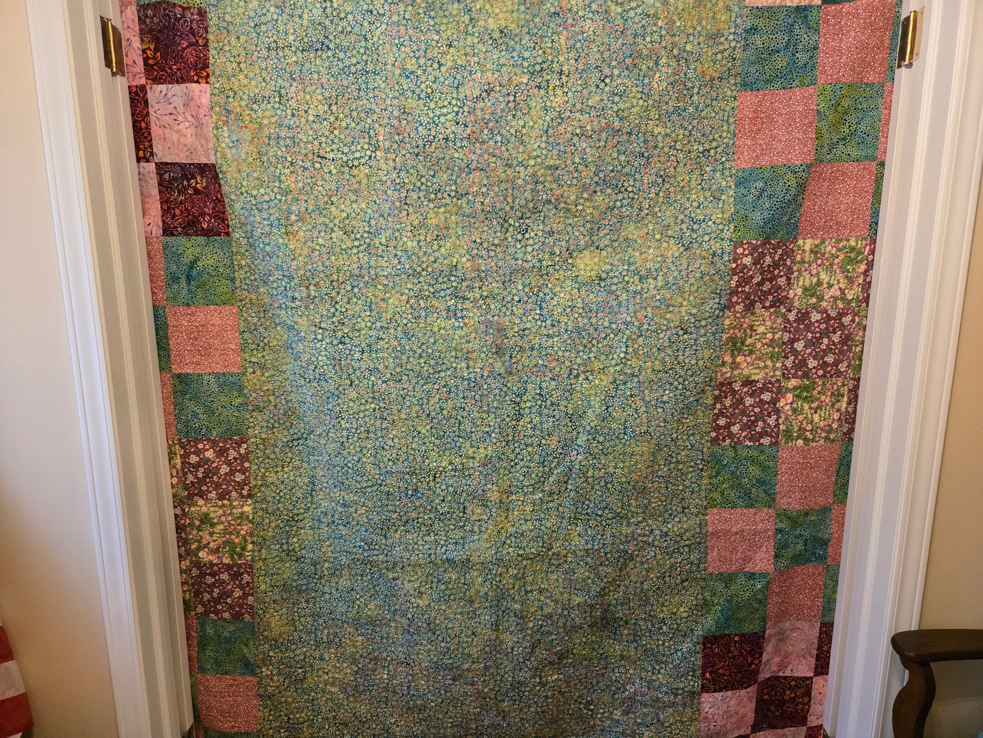 This shows the back of the quilt.  I have to take backing fabric that is 10 inches larger all around to the quilter.  I started with a solid teal and pink batik and put pink and teal nine patchs on both sides.  They're cut off where the quilt ends. 