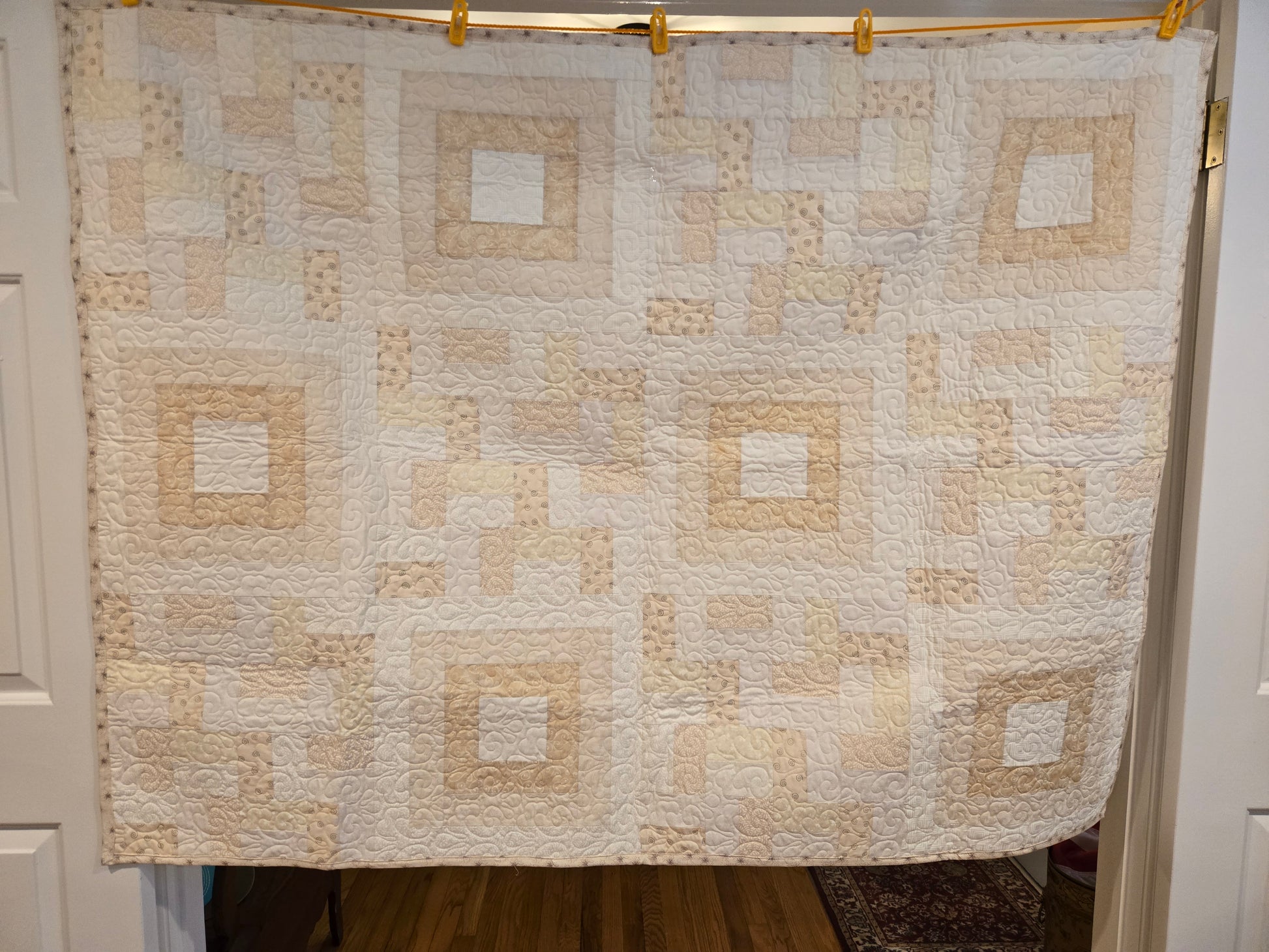 photo showing the entire white/beige quilt. With square in square blocks and rail blocks