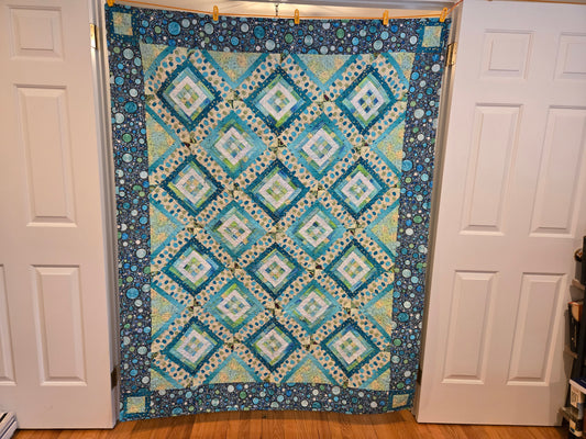 Blue patchwork quilt with corner squares. 