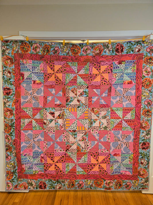 Kaffe Fassett fabric pink quilt with flywheels with extra parts.  Beautiful floral trim. 